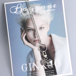 Silver bead chain keychain with heart pendants on a stylish magazine cover