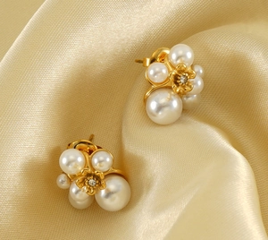 Detail of flower cluster pearl earrings with 18K gold floral center on silk