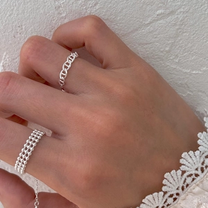 Detail of adjustable silver chain and beaded rings on fingers with lace cuff decoration