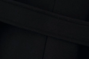 Macro shot of high-quality black wool fabric texture and fine stitching detail on coat