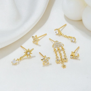 Detailed close-up of golden earring set with star, moon and cloud tassel charms