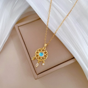 Gold dreamcatcher pendant necklace with blue gemstone and diamonds on silk background