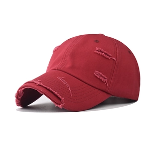 Close-up of distressed ripped details on deep red washed cotton canvas baseball cap