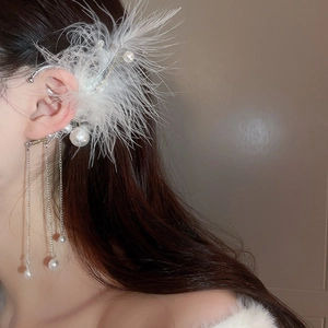 Close-up of elegant white feather and pearl tassel ear cuff with silver chains