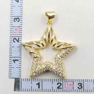 Mesure de la taille du pendentif étoile avec deux rubans à mesurer sur fond blanc
