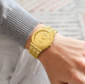 Close-up of CURREN gold square watch with horizontal textured dial and metal strap