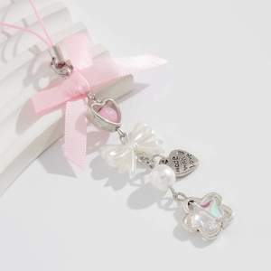 Close-up of pink ribbon bow phone strap with made with love engraved heart tag