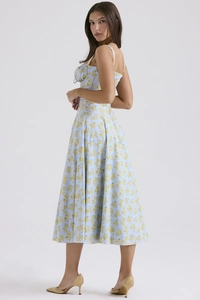 Detail of light blue floral midi dress featuring slim fit backless design and yellow flowers