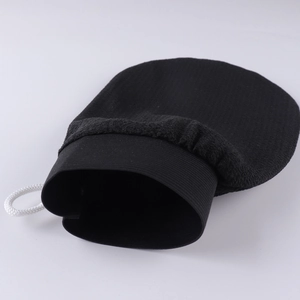 Detail of black exfoliating bath glove featuring elastic cuff and a white hanging loop