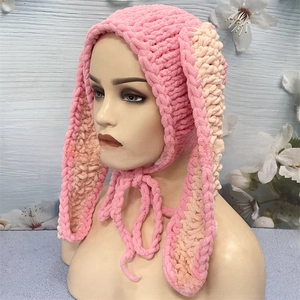 Detail of pink and beige crochet rabbit ear balaclava hat with soft knitted textures