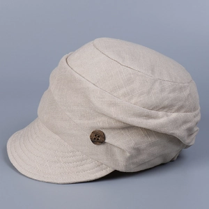 Detail view of beige linen flat top hat showing texture and a dark wooden button accent