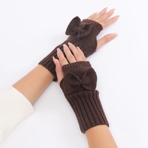 Detail of dark brown knitted fingerless gloves with a cute bow on a white background