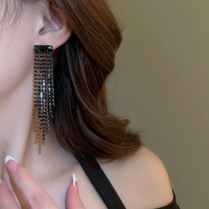 Close-up of black multilayer water drop tassel earrings with rhinestones on a model