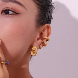 Detail shot of 18K gold plated rectangular earrings and textured ear cuffs for women