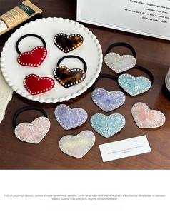 Macro shot of heart-shaped acetate hair accessories featuring sparkling rhinestone borders