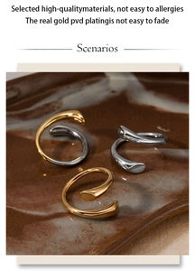 Artistic layout of dual-tone abstract curved open rings on vintage ceramic tray