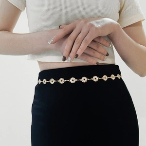 Close-up of a gold metal waist chain belt featuring sparkling rhinestones on the links