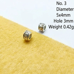 Macro detail of vintage silver spacer bead with floral engraving and 5x4mm dimensions