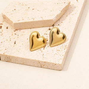 Minimalist 304 stainless steel heart earrings with polished 18K gold finish on travertine