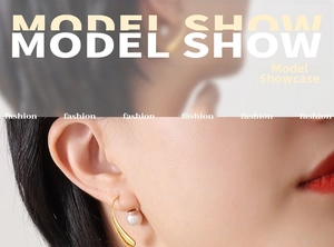 Detail view of gold teardrop pearl earrings worn by a model in a minimalist fashion style