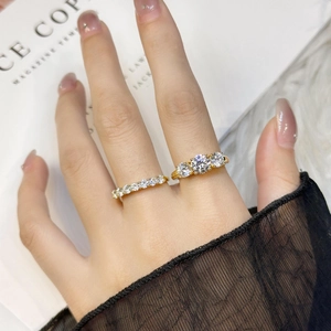 Close-up of a classic 1ct solitaire ring set with paved gold band on a hand model