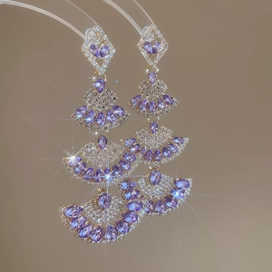 Detail of layered fan-shaped drop earrings with purple zircon stones and silver plating