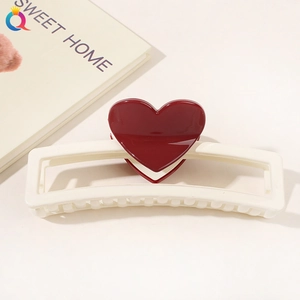 Detail of cream square hair claw clip featuring a 3D dark red heart on a white background