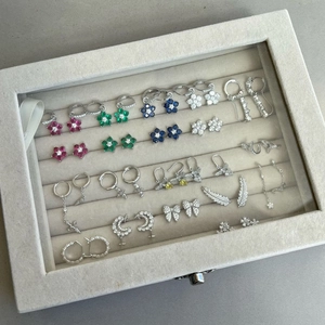 Flat lay of diverse S925 sterling silver earrings with colorful zircons in a jewelry box