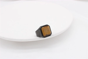 Detail of a square tiger eye stone set in a black stainless steel ring for men