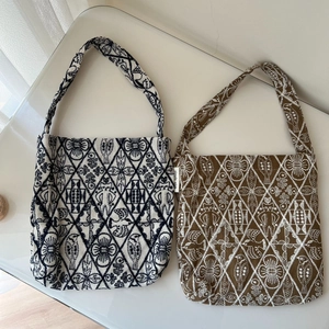 Detail of vintage ethnic embroidery on canvas mini tote bags with geometric floral motifs