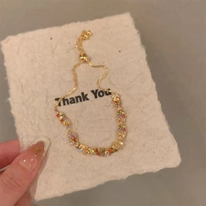 Bracelet doré ajustable avec une rangée de pierres en zircon colorées au design élégant