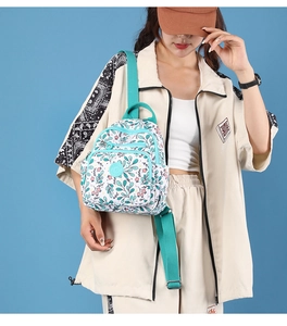 Detailed side view of floral print nylon mini backpack with adjustable green straps on model