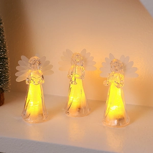 Close-up of three LED acrylic angel figurines holding musical instruments with warm lights
