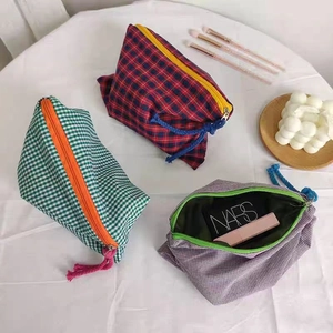 Classic checkered fabric cosmetic bags in red, green, and purple with fringe zippers
