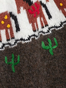Close-up of Fair Isle knit sweater showing reindeer jacquard and soft cactus embroidery