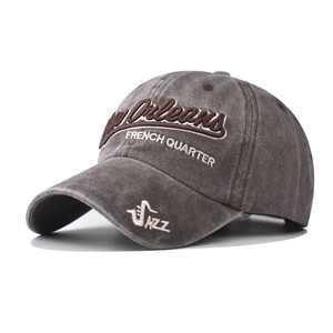 Detailed macro view of vintage washed grey cotton baseball cap with 3D letter embroidery