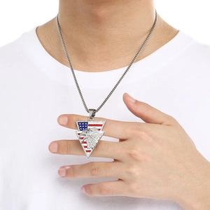 Detail of eagle and flag pendant on a silver chain worn by a model in a white t-shirt