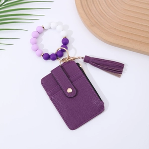 Detail of purple silicone beaded wristlet with leather card holder and tassel keychain