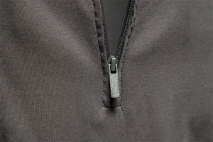 Macro shot of dark grey long sleeve polo shirt featuring a premium metal zipper detail