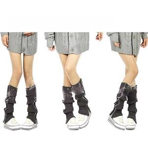 Detail of dark grey knitted leg warmers with side metal zipper and slouchy texture