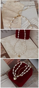Detailed macro view of baroque freshwater pearl necklace with gold heart pendant