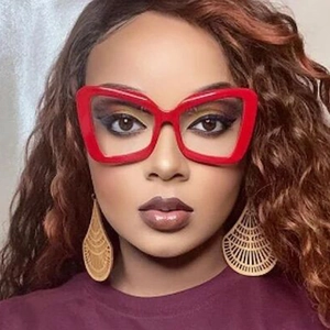 Front view of a model wearing large red irregular cat-eye frames with blue light blocking