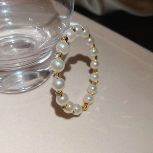 Detail of beaded pearl bracelet with gold metal spacers and sparkling rhinestones
