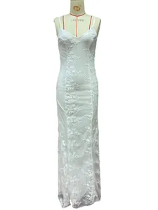 Detail of white maxi dress featuring delicate floral embroidery on sheer lace fabric