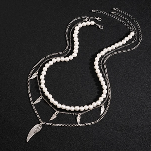 Men's multi-layer necklace set with white pearls and silver wing pendants on dark background
