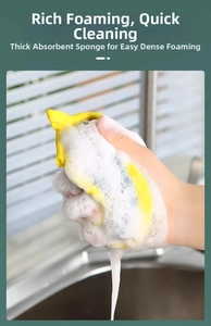 Close-up of hand squeezing high-absorbent yellow sponge with rich white cleaning foam