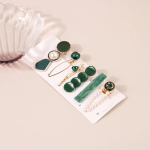 Détail de pinces à cheveux vert vintage avec perles et strass sur plat en verre