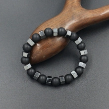 Close-up of black matte beads and polished metallic polyhedral beads on a wooden stand