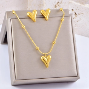 Detail of gold-plated heart necklace and stud earrings set in a premium gray jewelry box
