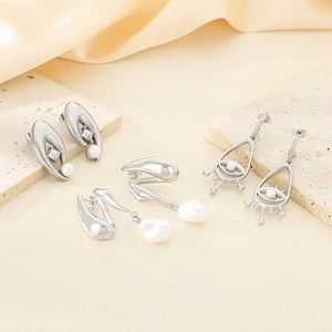 Détails de boucles d'oreilles en acier argenté avec perles sur support de pierre